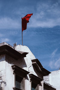 Low angle view of flags on building against sky