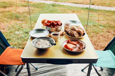 Family having breakfast outdoors on camping during summer vacation