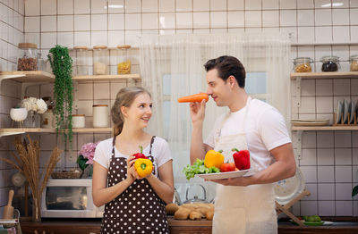 Smiling couple preparing meal together in kitchen at home