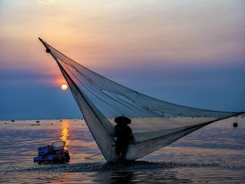 Sailboat on sea against sky during sunset