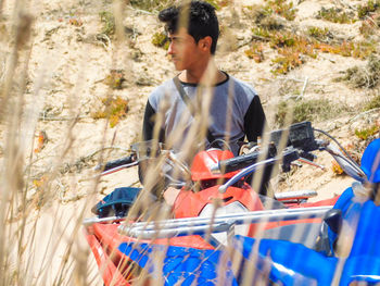 Young man looking away while sitting on quadbike