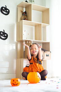 Full length of girl sitting on floor at home