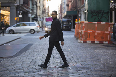 Full length of man walking on street in city