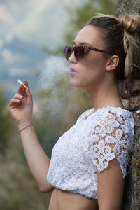 Side view of woman smoking cigarette