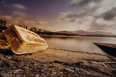 Abandoned boat on beach against sky