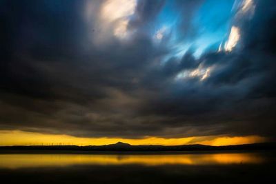 Scenic view of mountains against cloudy sky at sunset