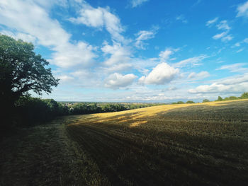 Road amidst field against sky