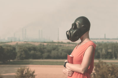 Portrait of young woman looking away against sky