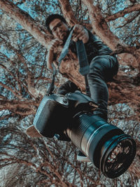 Midsection of man holding tree trunk in forest