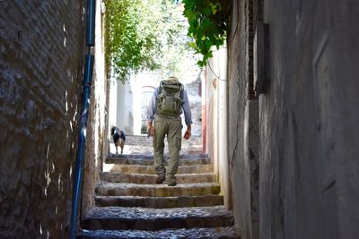 Rear view of man on stairway amidst buildings