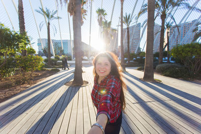 Portrait of smiling young woman with palm trees