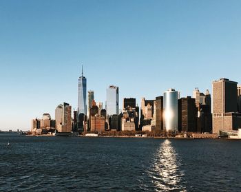 City at waterfront against clear sky