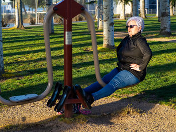 Full length of senior woman exercising at playground