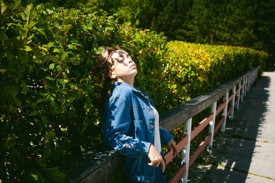 Woman standing against plants in park