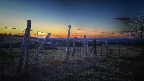 Scenic view of field against sky at sunset