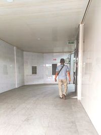 Rear view of man standing in corridor of building