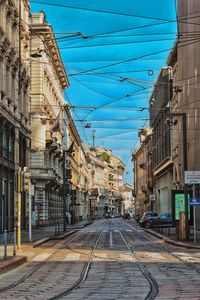 Empty road amidst buildings in city