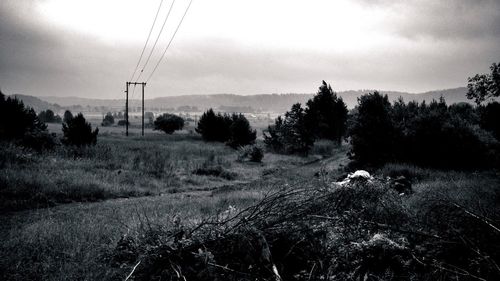 Electricity pylon on field against sky