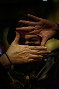 Close-up of man gesturing in darkroom