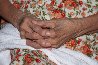 Midsection of senior woman with hands clasped