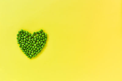 Directly above shot of heart shapes on yellow background