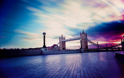 Bridge over river against cloudy sky