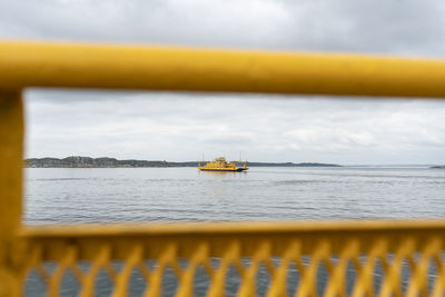 Scenic view of a yellow car ferry at sea against sky