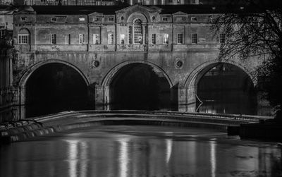 Reflection of illuminated bridge over water at night