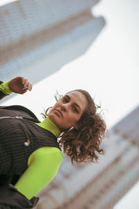 Portrait of woman against buildings in city