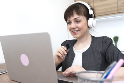 Portrait of young woman using laptop at table