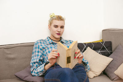 Young woman sitting on sofa