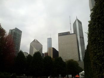 Low angle view of modern buildings against cloudy sky
