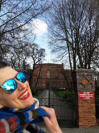 Portrait of happy woman against bare tree