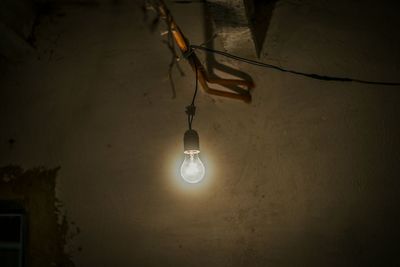 Low angle view of electric lamp hanging on ceiling