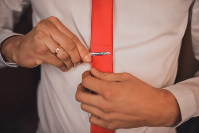 Midsection of man holding tape measure