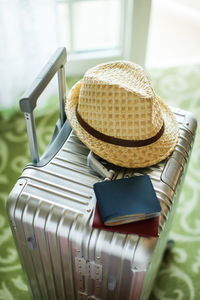 Close-up of hat and wallet with passport on suitcase