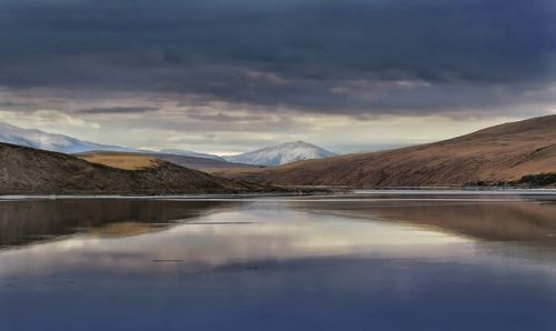 Scenic view of lake and mountains against sky