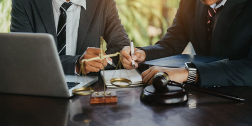 Midsection of business people working on table