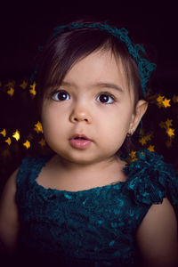 Girl in blue dress in studio with gold sequins and garland