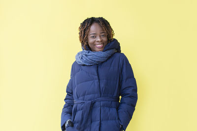 Portrait of smiling man standing against yellow background