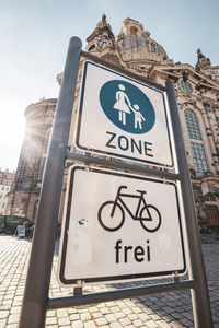 Low angle view of road sign against building in city