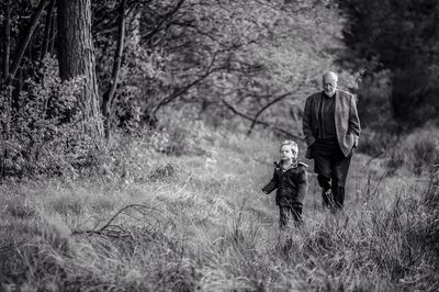 Man and boy walking in forest