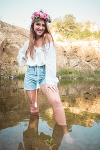 Portrait of smiling young woman standing in lake