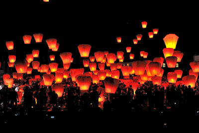 Illuminated lanterns against sky at night