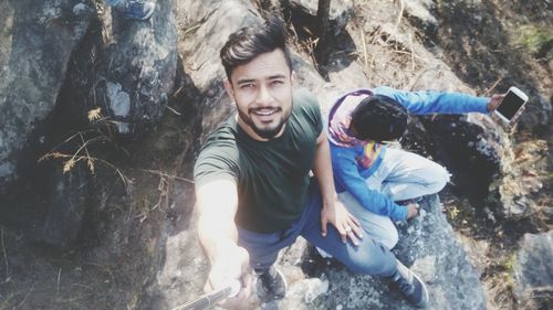 Portrait of smiling young man on rock