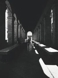 Rear view of people walking in colonnade at historical building