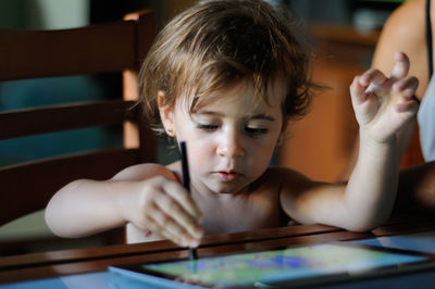 Shirtless girl using digital tablet at home