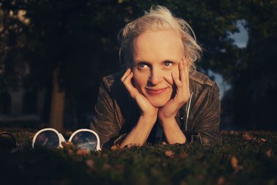 Woman looking away while lying on field