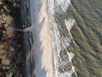 Aerial view waves crashing on coastline