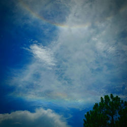 Low angle view of rainbow against blue sky